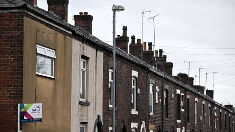 An estate agent's 'for sale' board is pictured on a house at the end of a row of terraced homes in northern England on November 2, 2022. 